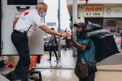 Profissional de saúde auxilia um homem em situação de rua ao ar livre.