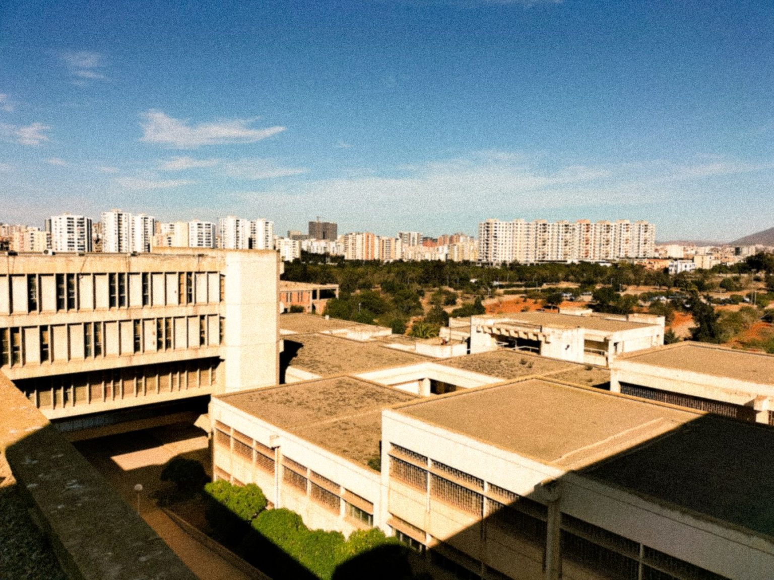 Vista aérea de edifícios residenciais de concreto sob céu azul.