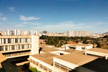 Vista aérea de edifícios residenciais de concreto sob céu azul.