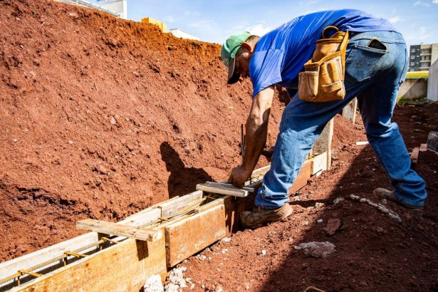 Trabalhador da construção civil executa a fundação de um edifício em um canteiro de obras.