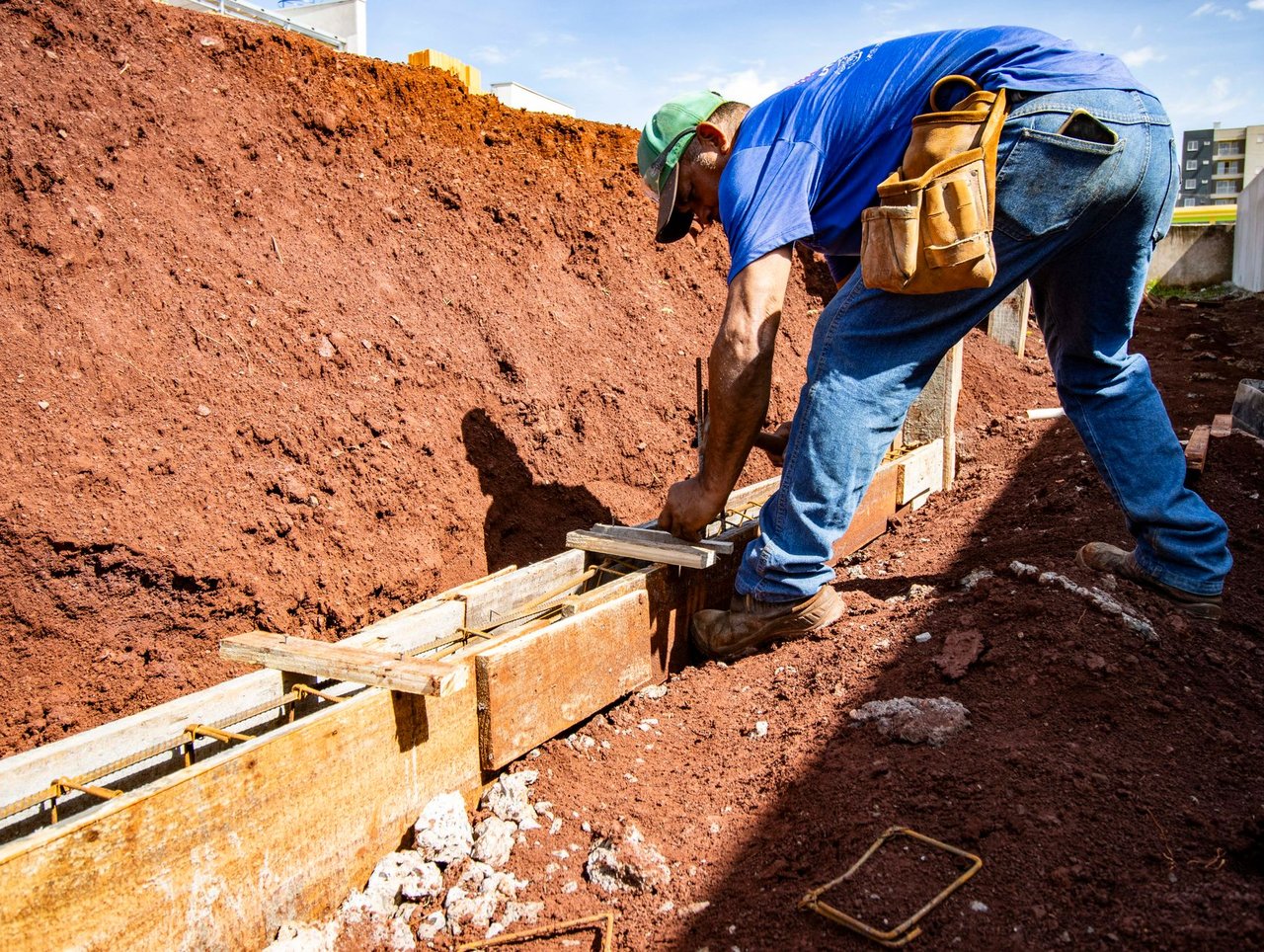 Trabalhador da construção civil executa a fundação de um edifício em um canteiro de obras.