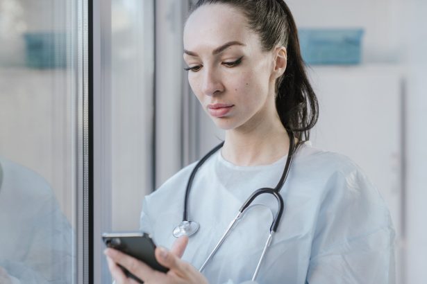Médica usando um smartphone em um ambiente hospitalar.